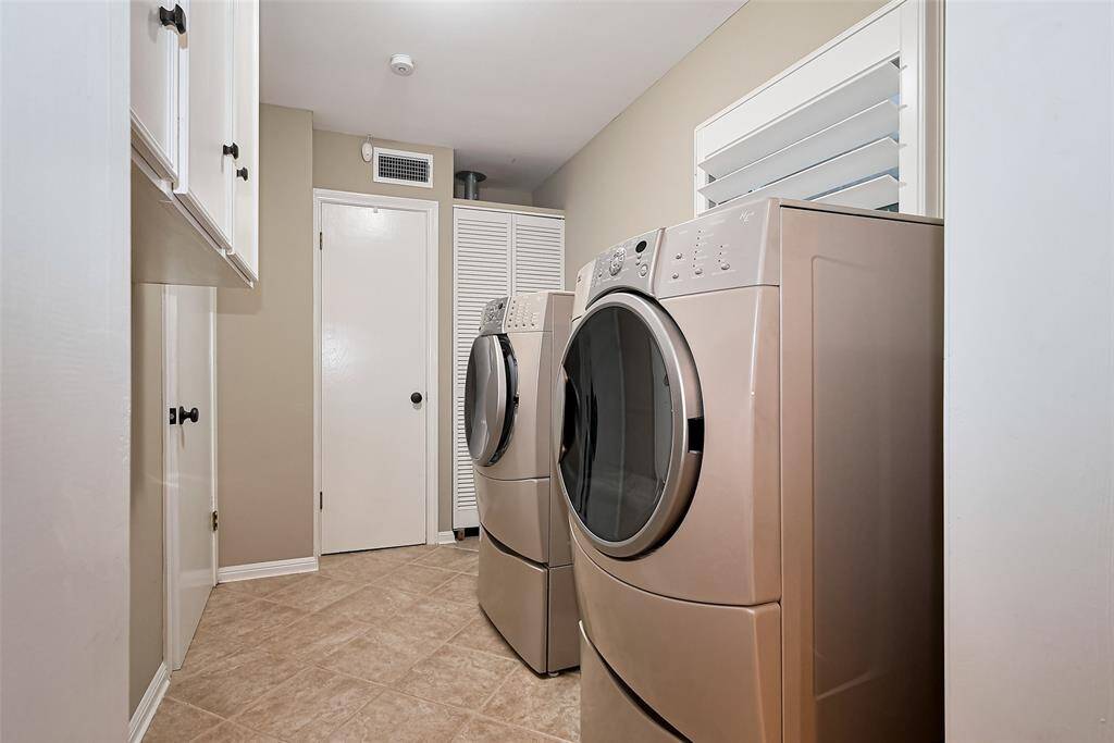 Laundry room has a coat or broom closet, upper cabinets, tile floor and adjacent to the entry/mud room.