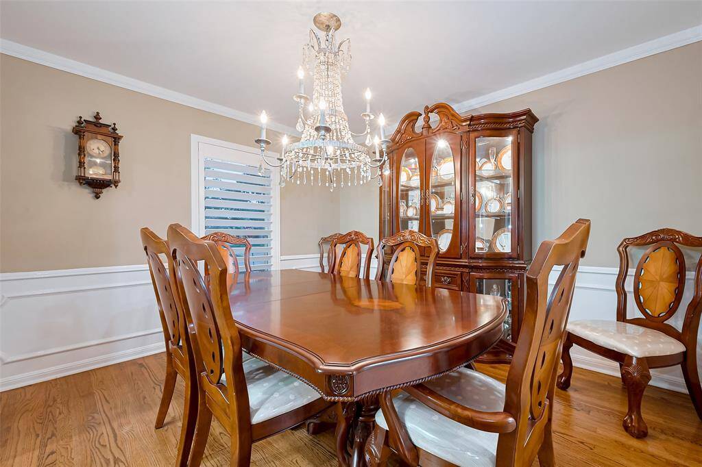 Formal dining room has wainscot and crown moldings.