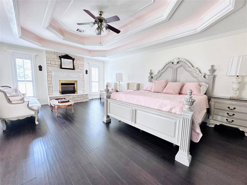 Primary bedroom is nestled in its private wing of the home.  Curl up by the fireplace in this spacious suite.