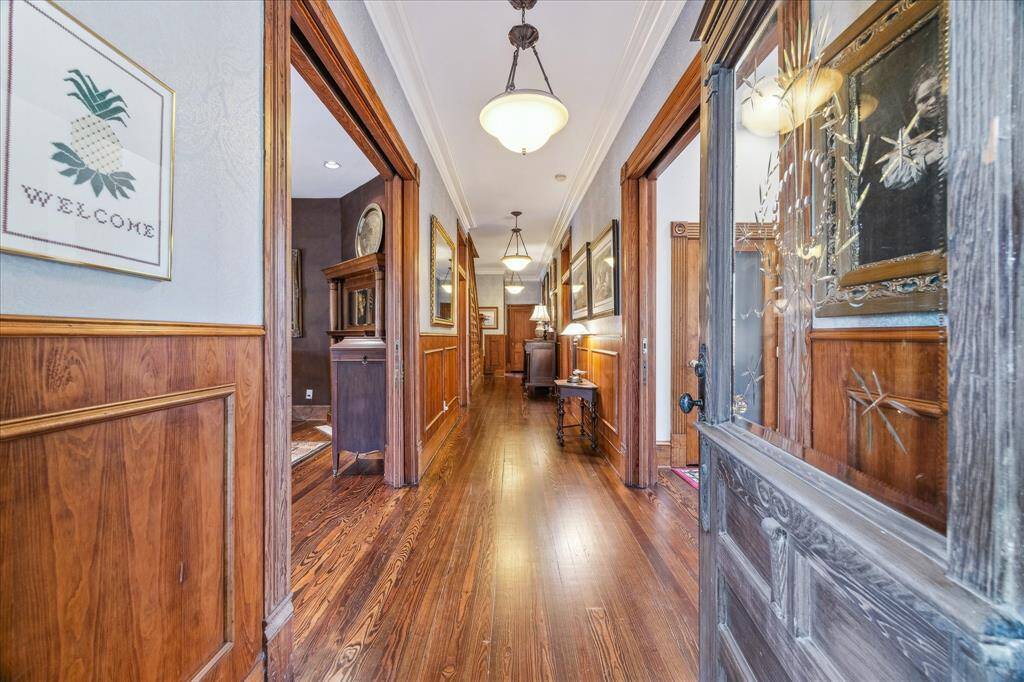 Enter in to this grand  foyer offering pocket doors, timeless lighting, and amazing woodwork.