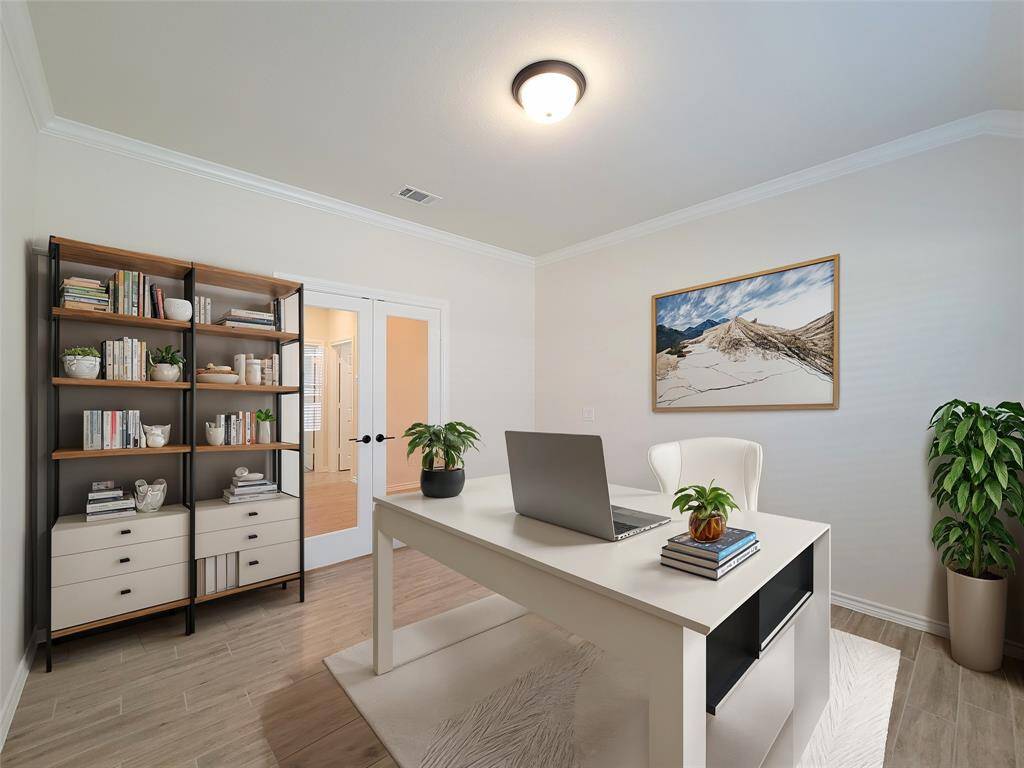 Elegant home office featuring exquisite 4.25" crown molding and bright full-lite doors, presented with tasteful virtual staging.
