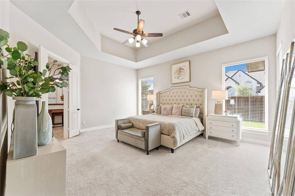 Private primary suite with tray ceiling and views to the backyard. Virtually Staged.
