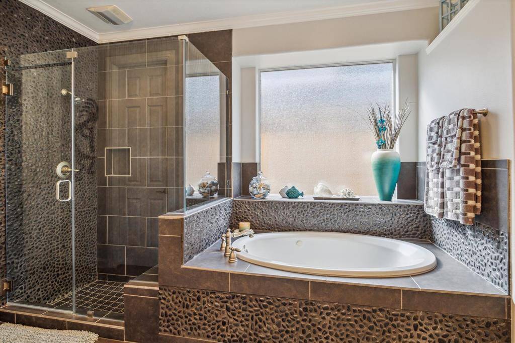 DESIGNER STYLE IN THIS ENSUITE PRIMARY BATHROOM - frameless glass shower surround and oval tub for relaxing - large translucent glass window provides filtered light