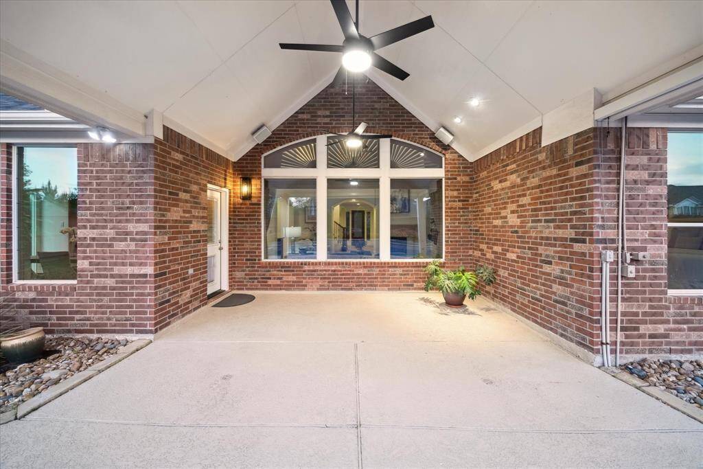 Enjoy the perfect balance of comfort and style in this covered patio, complete with a solar screen for added shade and a ceiling fan to keep the air cool.