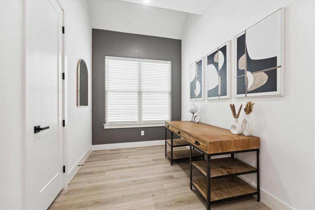 An oversized window invites plenty of natural light, working seamlessly with recessed lighting to create a bright and welcoming atmosphere.