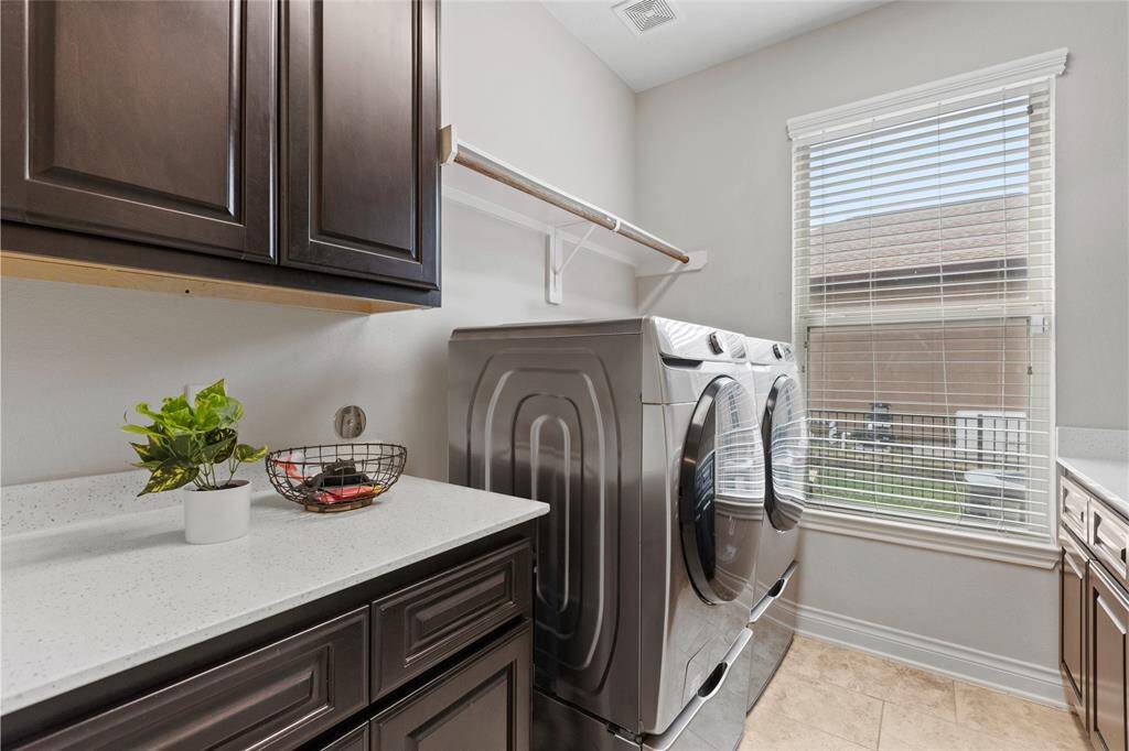 Also located on the first floor is a well appointed laundry room, complete with custom cabinetry, ample counterspace and utility sink.