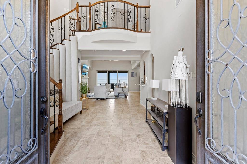 A grand entrance that sets the tone for luxury—soaring ceilings, custom wrought iron details, and a breathtaking open-concept design with stunning lake views.
