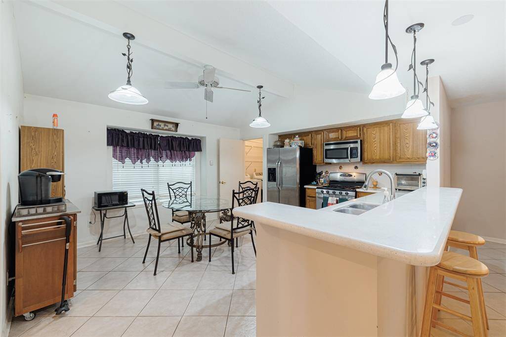 Kitchen and breakfast room combo features a breakfast bar with pendant lighting.