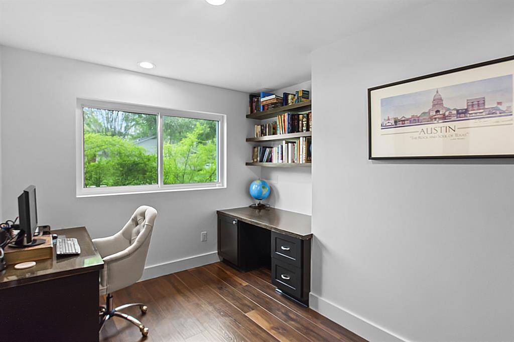 Located immediately off the foyer, the private home office is complete with custom built-in cabinetry, desks and shelving.