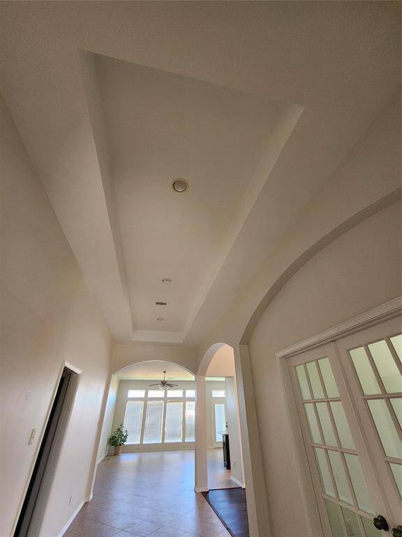 Step into the grand entry gallery, where soaring coffered ceilings and exquisite architectural details set the stage for elegance. Thoughtfully designed with graceful arches, stylish niches, and distinctive corner accents, this space creates a warm, airy ambiance that welcomes you home with sophistication and charm.