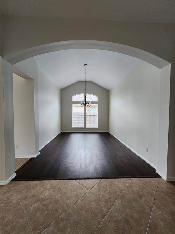 The formal dining room boasts soaring ceilings and exquisite architectural details, including elegant corners and graceful arches. Sunlight pours in, highlighting the rich, gleaming wood floors and creating a warm, inviting ambiance. This beautifully designed space effortlessly combines sophistication and charm, making it perfect for both intimate dinners and grand gatherings.