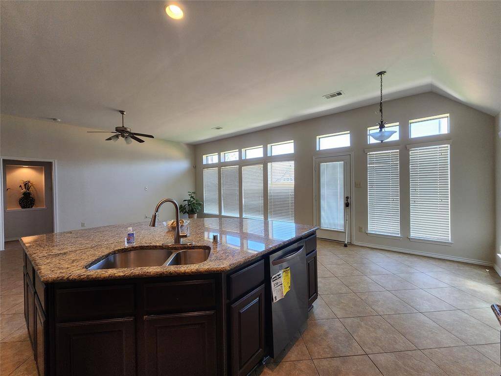 Enjoy a stunning view of the kitchen island, featuring a brand-new stainless steel dishwasher, seamlessly blending style and functionality. Beyond the island, the spacious breakfast area offers the perfect setting for casual dining and morning gatherings.