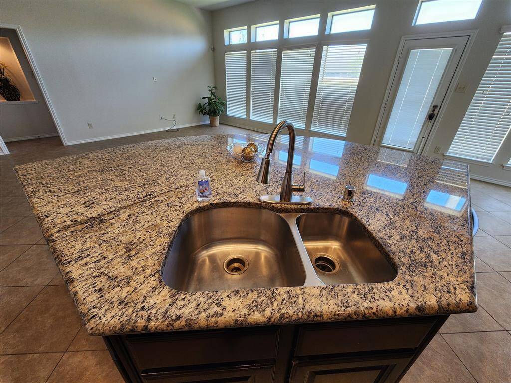 Enjoy a stunning top-down view of this beautifully designed circular island, featuring an elegant granite countertop. Thoughtfully crafted for convenience, the island seamlessly integrates a sink and dishwasher, making meal prep and cleanup effortless. A perfect blend of style and functionality, this centerpiece enhances both the aesthetic and efficiency of your kitchen.