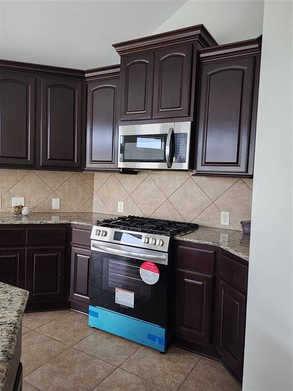Featuring brand-new stainless steel appliances, this kitchen is equipped with a sleek microwave vent hood combo installed above a new gas 5-burner stove, offering both style and functionality for all your cooking needs.