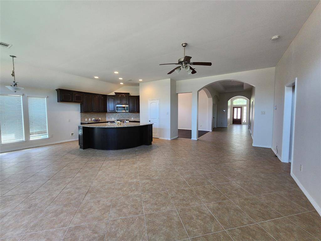 The gourmet kitchen is a chef’s dream, featuring a stunning circular granite island with seating for four, perfect for casual dining and entertaining. The thoughtfully designed layout ensures comfort and convenience.