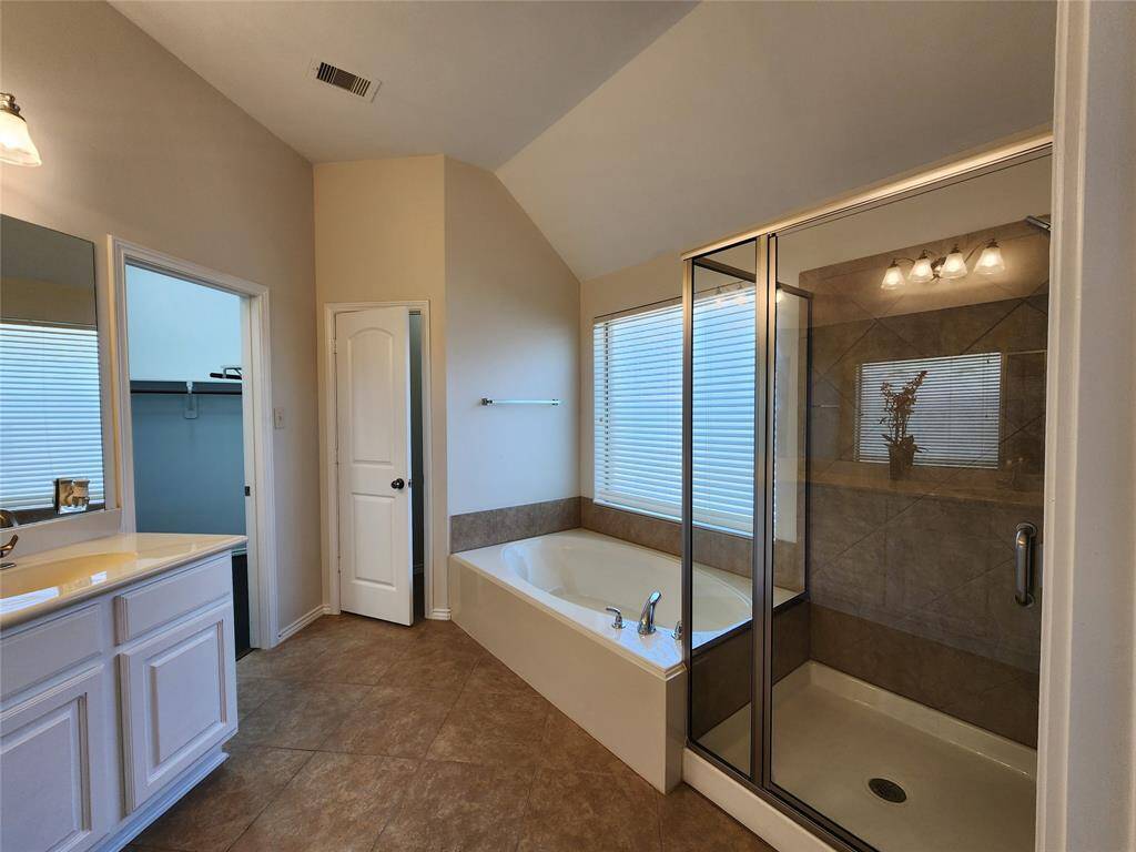 Escape into luxury in the primary bath, where tranquility meets elegance. Enjoy the privacy of a separate toilet closet, while the oversized glass-enclosed shower offers a spa-like retreat. Unwind in the expansive oval soaking tub, bathed in natural light streaming through a beautifully textured glass window—creating the perfect oasis for relaxation.