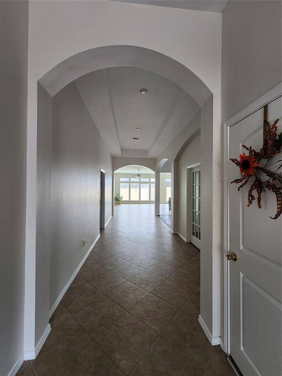 Step into the grand entry gallery, where soaring coffered ceilings and exquisite architectural details set the stage for elegance. Thoughtfully designed with graceful arches, stylish niches, and distinctive corner accents, this space creates a warm, airy ambiance that welcomes you home with sophistication and charm.