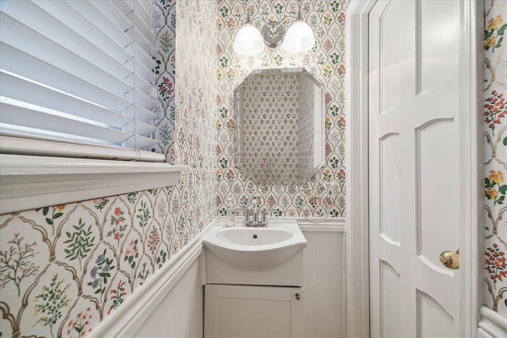 The charming half bathroom is located between the kitchen and the backyard. Great for guests and for owners when coming in from outdoors.