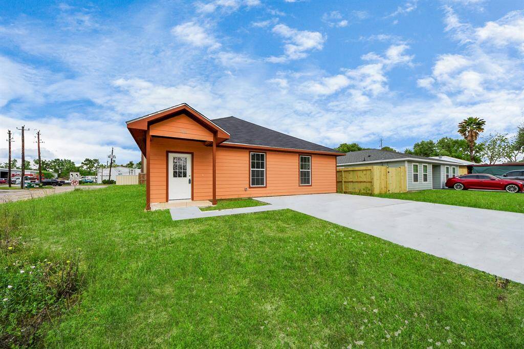 This is a charming single-story home with a vibrant orange exterior. It features a welcoming front porch, a spacious driveway, and a neatly maintained lawn. Ideal for buyers seeking a cozy and colorful home.