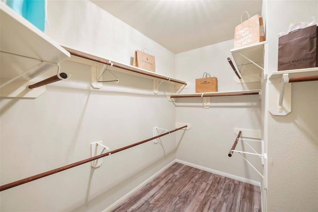 Large walk-in primary closet with plenty of shelving and hangers for your clothes