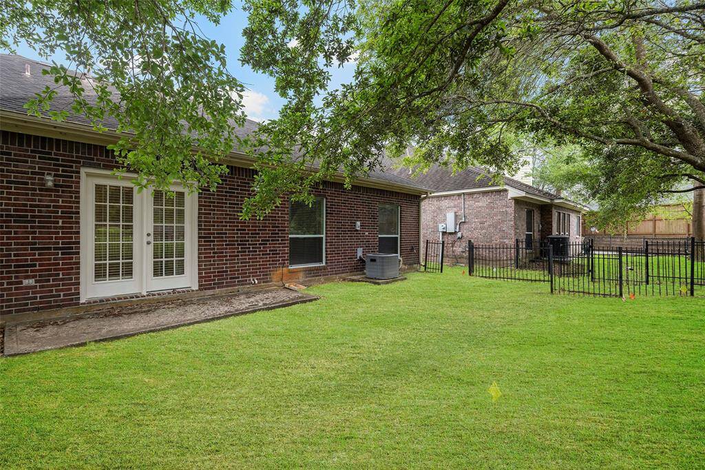 View of the backyard area with metal fencing.