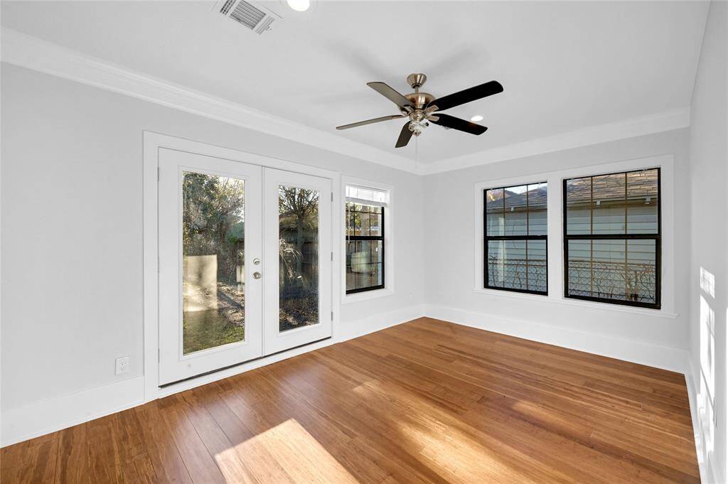 Large primary bedroom with dual patio doors. The doors open to the back yard