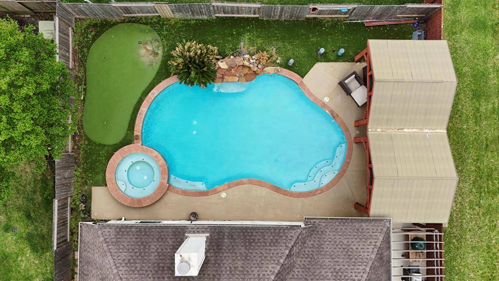 A stunning aerial view of your new home and backyard oasis—showcasing the sparkling pool, spacious layout, and beautifully maintained outdoor living spaces.