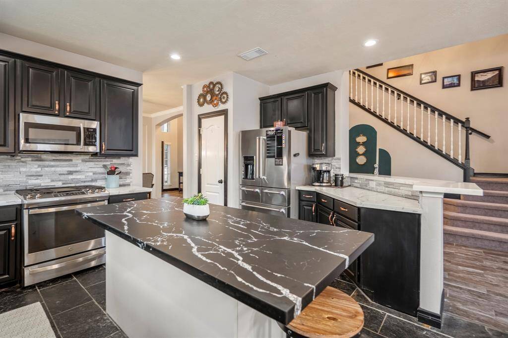 The updated kitchen boasts a 2020 remodel that checks all the boxes—sleek quartz countertops, a stylish backsplash, freshly repainted cabinets with updated hardware, and stainless steel appliances throughout. The undermount stainless steel sink and modern faucet add the perfect finishing touch to this functional and beautiful space.