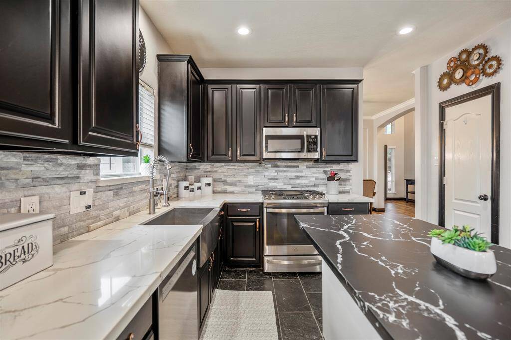 The updated kitchen boasts a 2020 remodel that checks all the boxes—sleek quartz countertops, a stylish backsplash, freshly repainted cabinets with updated hardware, and stainless steel appliances throughout. The undermount stainless steel sink and modern faucet add the perfect finishing touch to this functional and beautiful space.