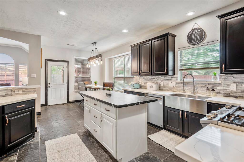 The updated kitchen boasts a 2020 remodel that checks all the boxes—sleek quartz countertops, a stylish backsplash, freshly repainted cabinets with updated hardware, and stainless steel appliances throughout. The undermount stainless steel sink and modern faucet add the perfect finishing touch to this functional and beautiful space.