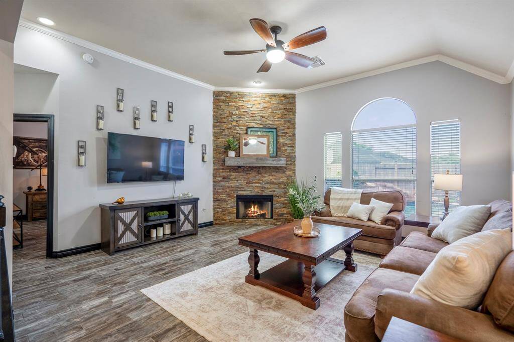 The family room is bright and welcoming, featuring abundant natural light, refreshed paint, wood-look tile flooring, and a stunning redesigned stacked-stone fireplace as the focal point. Whether you're cozied up for a movie night or simply gazing out at your backyard oasis, this space was made for relaxing