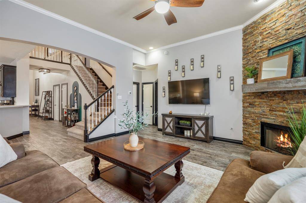 The family room is bright and welcoming, featuring abundant natural light, refreshed paint, wood-look tile flooring, and a stunning redesigned stacked-stone fireplace as the focal point. Whether you're cozied up for a movie night or simply gazing out at your backyard oasis, this space was made for relaxing