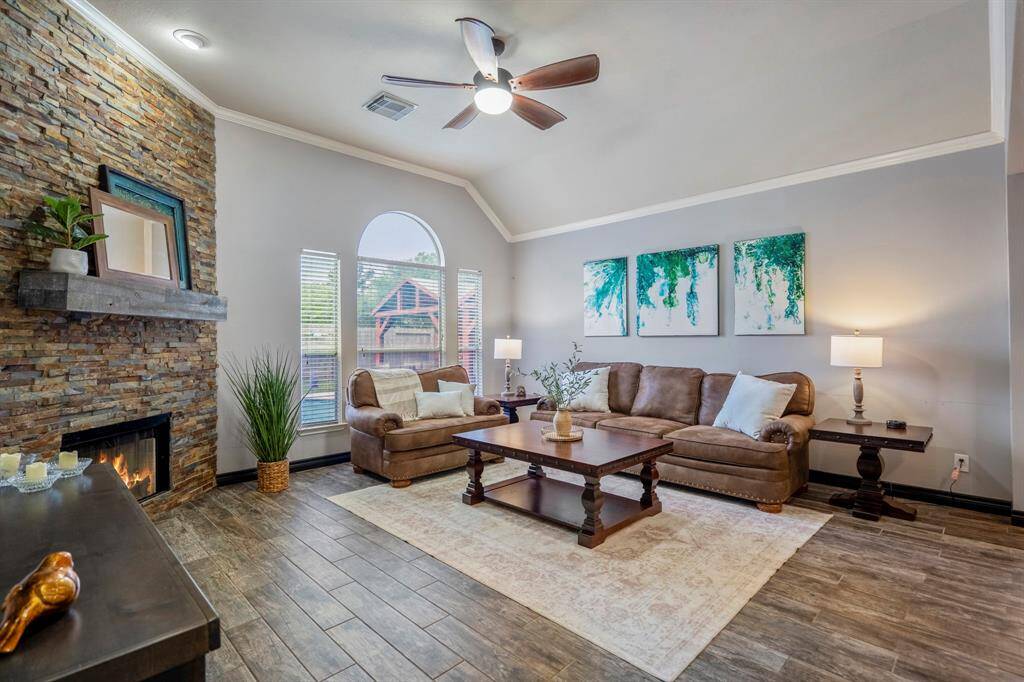 The family room is bright and welcoming, featuring abundant natural light, refreshed paint, wood-look tile flooring, and a stunning redesigned stacked-stone fireplace as the focal point. Whether you're cozied up for a movie night or simply gazing out at your backyard oasis, this space was made for relaxing