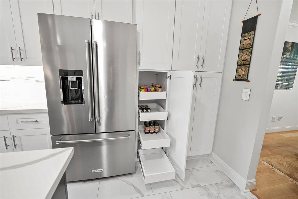 The thoughtfully designed cabinetry features pull-out drawers, ensuring that all your kitchen essentials are easily accessible and neatly organized, adding to the overall functionality of the space.