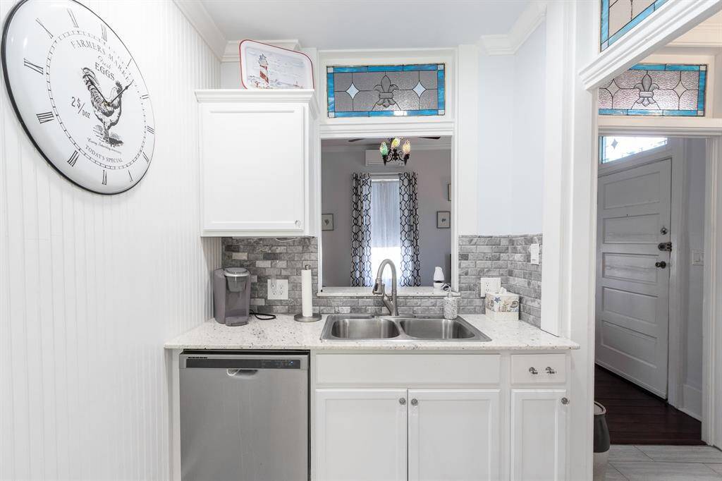 Downstairs kitchen with double sink and dishwasher. Den in the background and breakfast room to the right. Hand-made custom transoms.