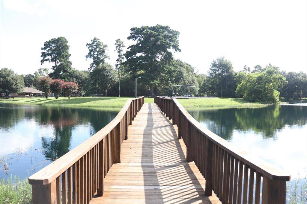 Bridge across the lake leads to shaded park and picnic area to enjoy a day with friends and family