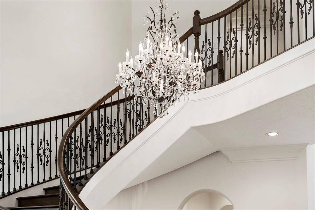 The grand staircase and soaring ceilings in the entryway are emphasized by this lovely Restoration Hardware chandelier