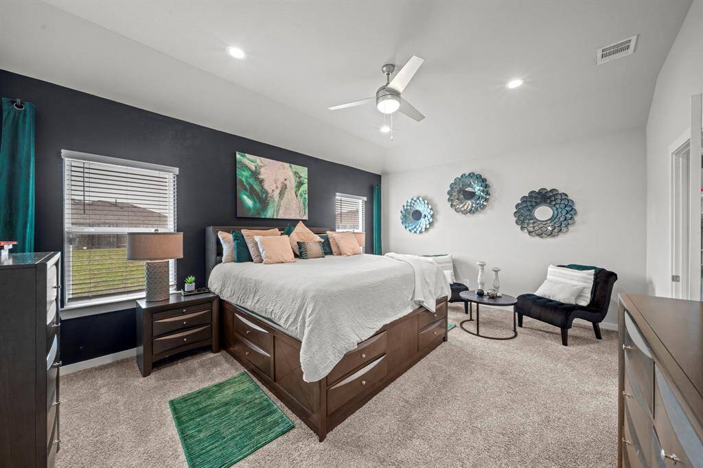 The serene primary suite (first floor) blends bold accents with cozy textures—perfect for rest, relaxation, and a little extra storage!