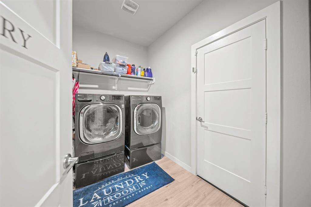 Laundry room with extra storage space above, washer & dryer included!