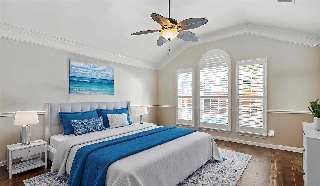 The primary suite exudes elegance with its chair rail, crown molding, and vaulted ceiling, adding depth and character to the space. Plantation shutters frame beautiful views overlooking the backyard.