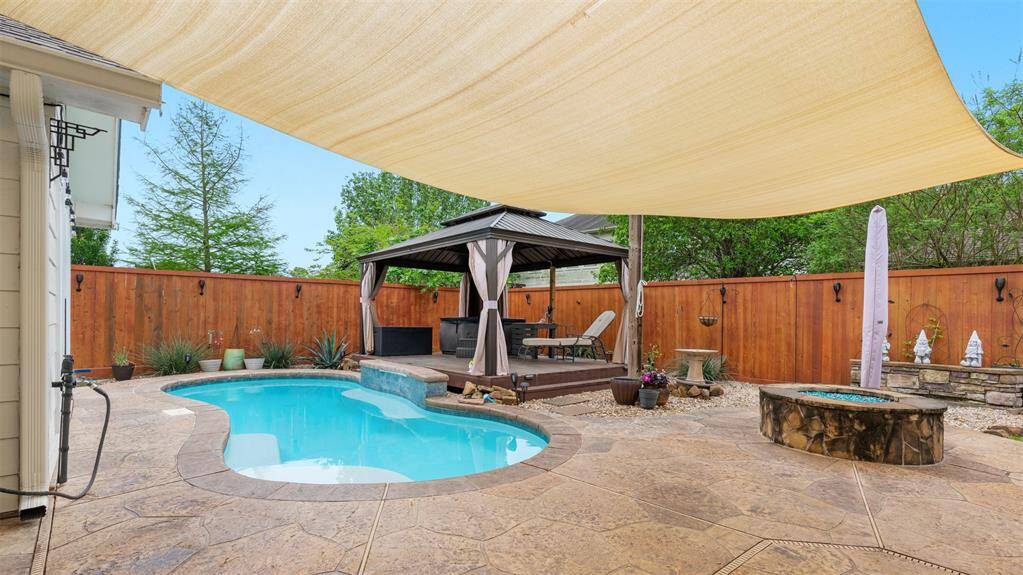 The backyard is an entertainer's dream, complete with a covered patio and outdoor kitchen. Enjoy a sparkling swimming pool, a cabana-like gazebo, and a cozy fire pit, creating an ideal space for relaxation and gatherings.