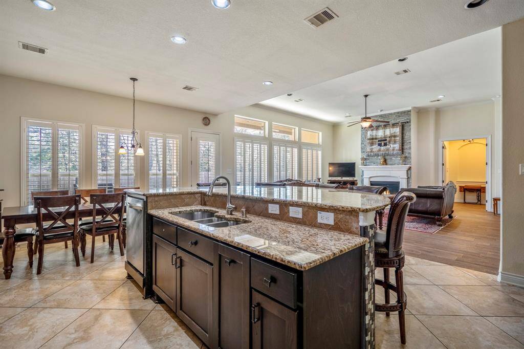 Anchored by a granite-topped island with bar seating and prep sink, this kitchen is the heart of the home. The open layout flows effortlessly into the breakfast nook and living room—ideal for casual meals or hosting guests.