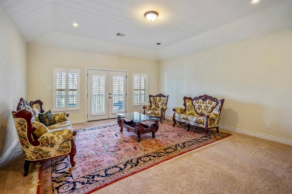 The spacious game room is ideal for casual entertaining or relaxing evenings. French doors open to the private upstairs balcony, while plush carpet adds comfort and warmth to this inviting space.
