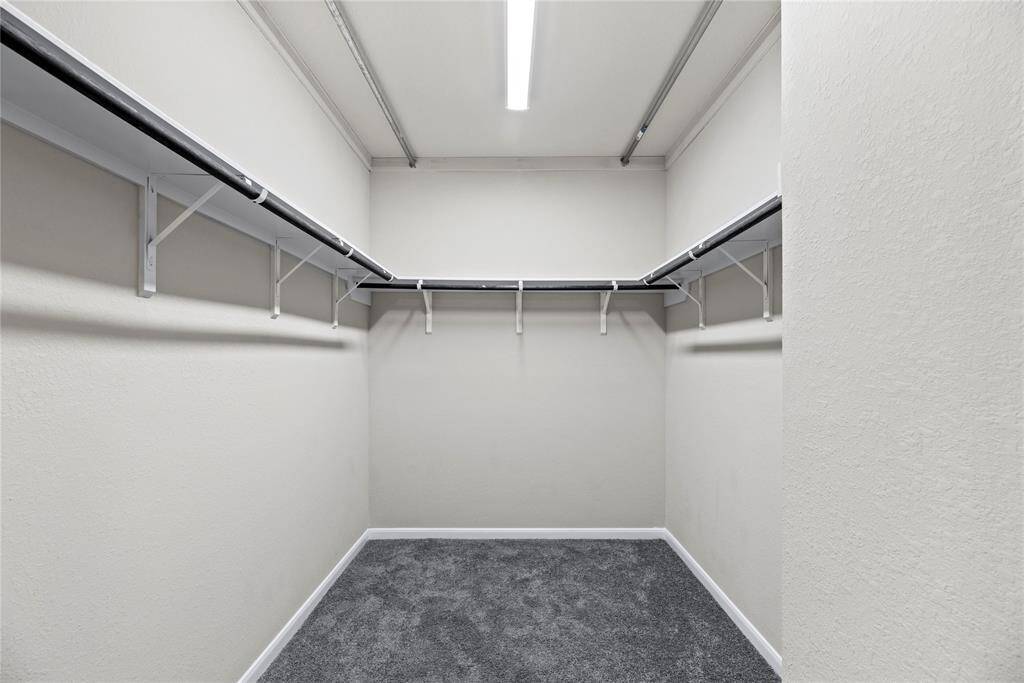 The primary closet offers ample space to store all your clothes and keep everything organized.
