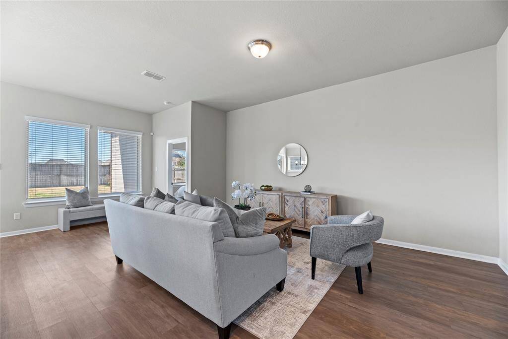 A chic living room space flooded with natural light is delightful! The wall of windows not only brings in abundant sunlight but also offers expansive views of the surrounding landscape, connecting the indoors with the outdoors in a seamless way.
