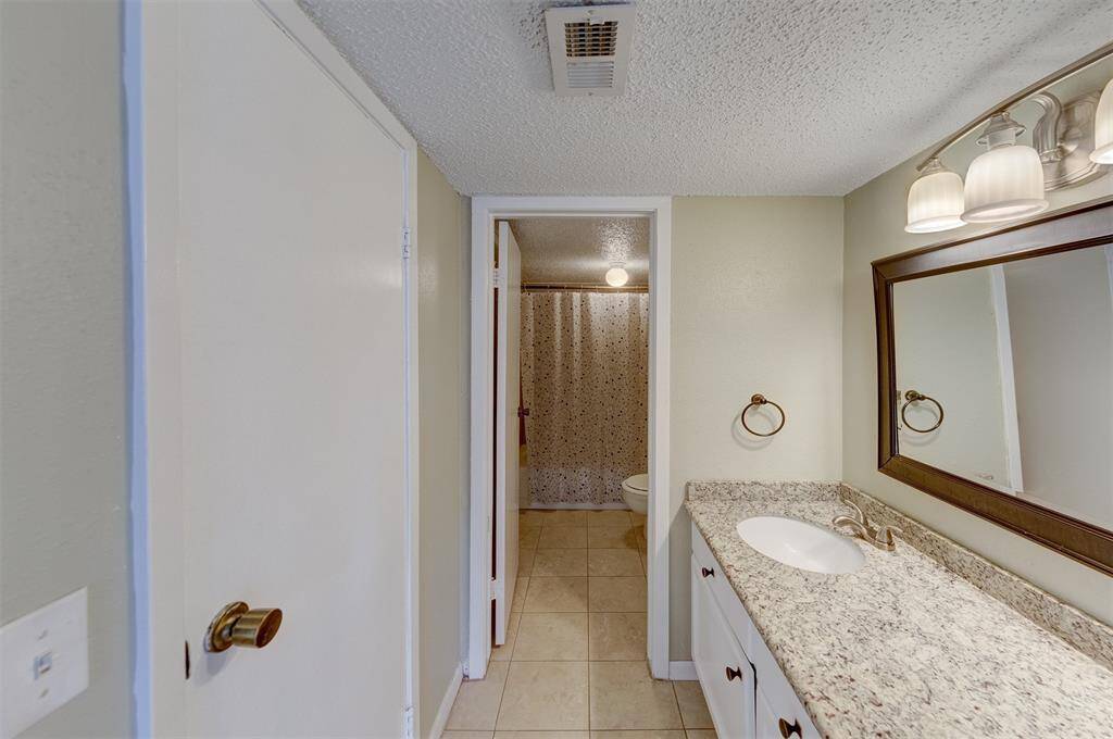 Full bathroom with granite countertops.