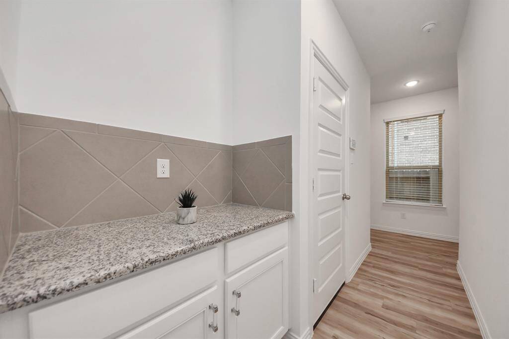 Hallway to garage and Utility room with extra storage.