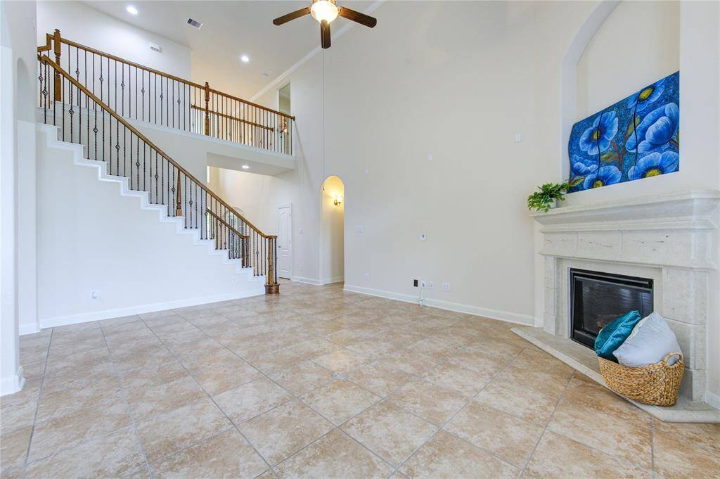 The family room has a cozy- gas-log fireplace. Together with the high ceilings adds warmth and ambiance to the home.