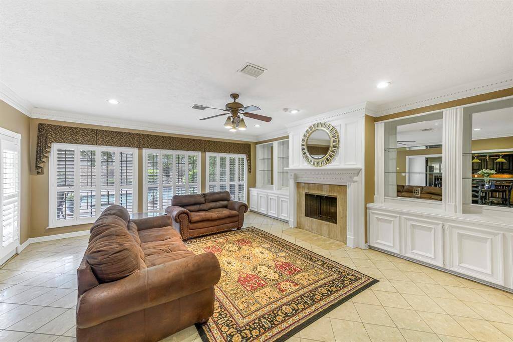 The windows along the back of the home are a stunning feature, allowing abundant natural light to pour into the interior while providing an unobstructed view of the backyard pool and surrounding outdoor spaces