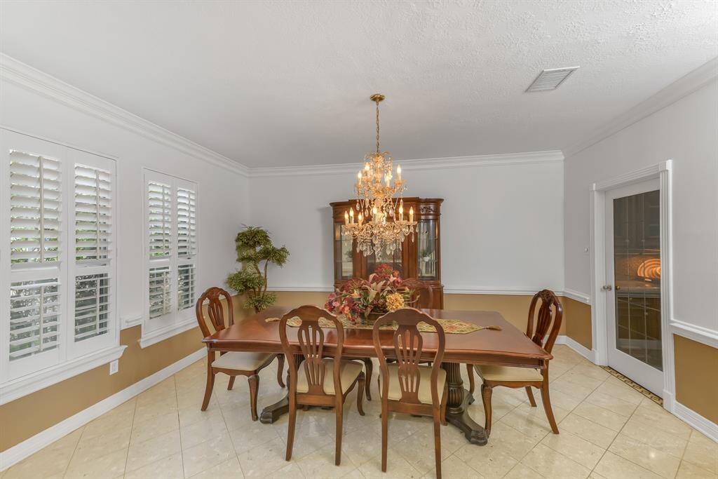 The room is framed by large windows adorned with plantation shutters, which provide a sense of refinement while allowing for adjustable light and privacy